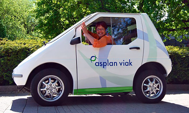 Person som vinker fra en liten elektrisk bil